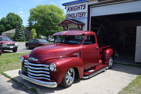 vintage maroon and chrome Chevy truck parked in front of Knights Upholstery front entrance