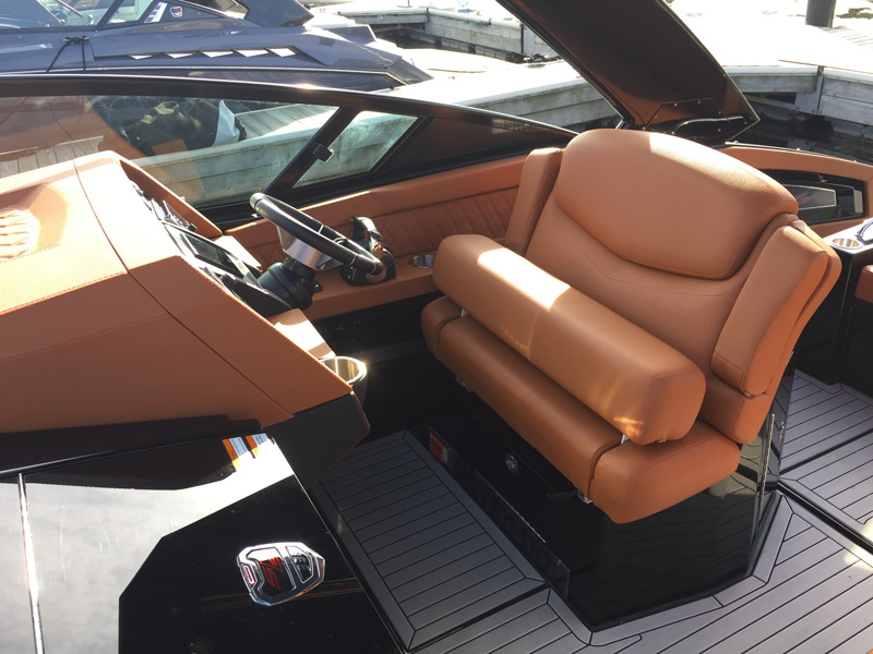 captains seat and steering column on boat with custom brown leather upholstery