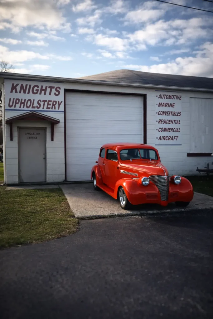 Red vintage car parked outside of Knights full-service upholstery shop