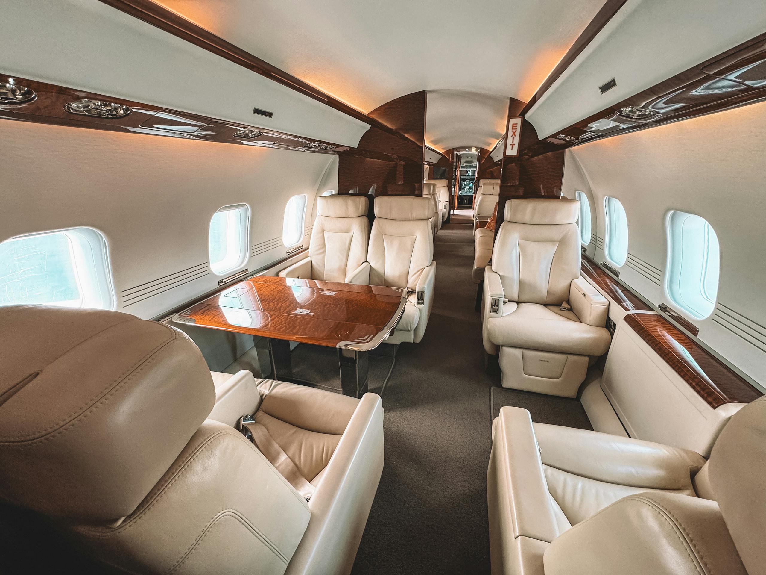 custom aviation upholstery on a private jet showcasing leather seating and elegant wooden trim.
